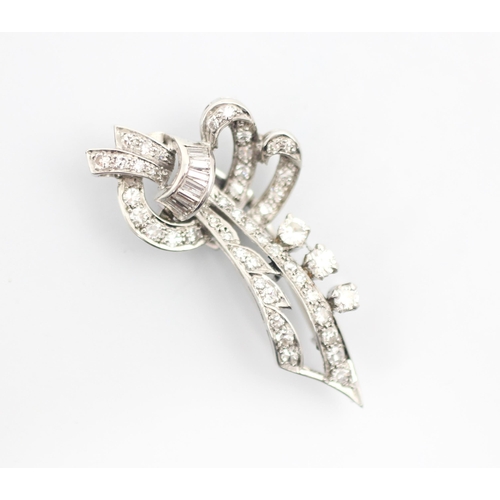 348 - A mid 20th century diamond brooch, the stylised spray brooch set with a band of baguette cut diamond... 