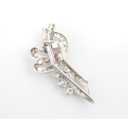 348 - A mid 20th century diamond brooch, the stylised spray brooch set with a band of baguette cut diamond... 