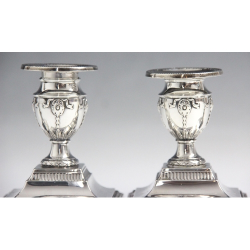 47 - A pair of Edwardian silver candlesticks, Hawksworth, Eyre & Co Ltd, Sheffield 1902, the urn shaped s... 