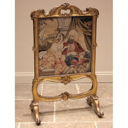 986 - A 19th century French giltwood and gesso Rococo fire screen, the swept frame with a 'C' scroll apert... 