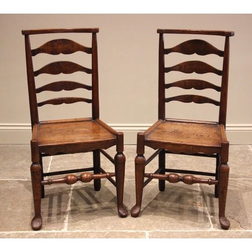 995 - A pair of 19th century provincial ash ladder back chairs, each with a board seat, shaped apron upon ... 