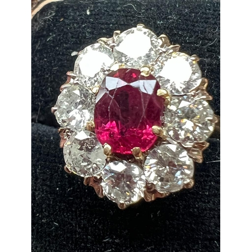 331 - An Edwardian style ruby and diamond cluster ring, the oval cut ruby within surround of eight round c... 