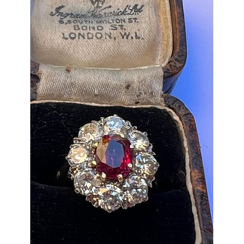 331 - An Edwardian style ruby and diamond cluster ring, the oval cut ruby within surround of eight round c... 