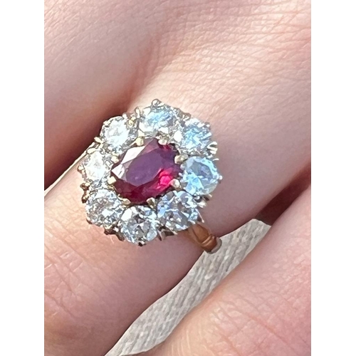 331 - An Edwardian style ruby and diamond cluster ring, the oval cut ruby within surround of eight round c... 