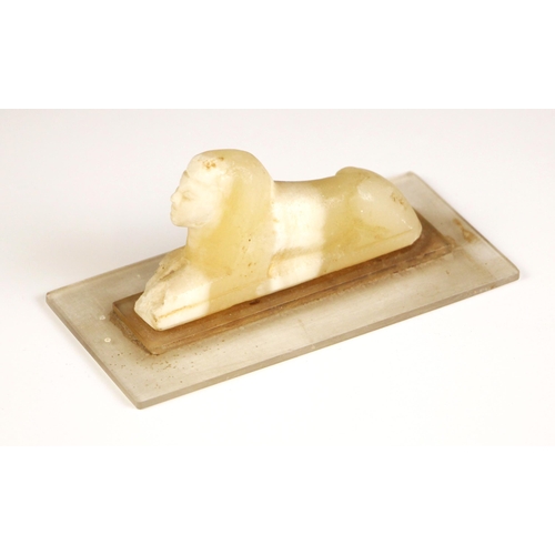 366 - An Egyptian Grand Tour carved alabaster Sphinx, modelled upon a perspex base, carving 9.5cm long