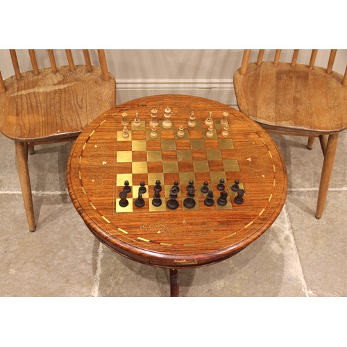 1065 - A brass inlaid hardwood pedestal chess table, late 20th century, the circular moulded top inlaid wit... 