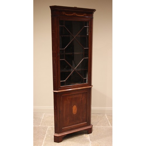 1037 - An Edwardian mahogany Sheraton revival freestanding corner cupboard, the moulded cornice over frieze... 