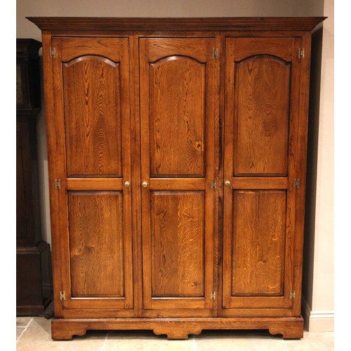 1063 - A Victorian style oak triple wardrobe, by Oakwood, Traditional Furniture, Chester, late 20th/early 2... 