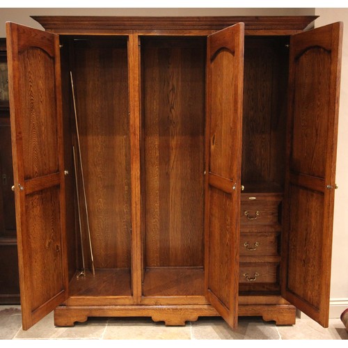 1063 - A Victorian style oak triple wardrobe, by Oakwood, Traditional Furniture, Chester, late 20th/early 2... 