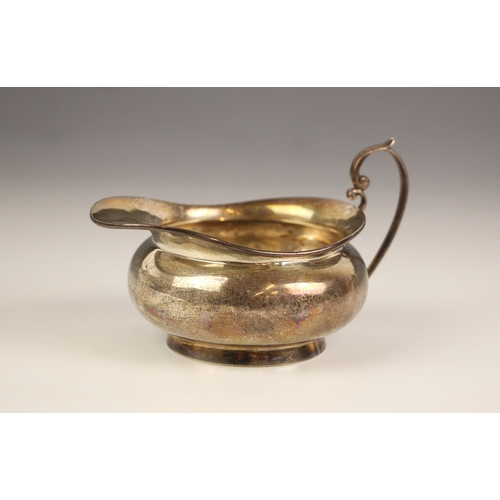 15 - A late 19th century silver milk jug, William Aitken, Birmingham, the stylised scroll handle above pl... 