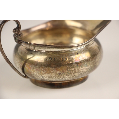 15 - A late 19th century silver milk jug, William Aitken, Birmingham, the stylised scroll handle above pl... 