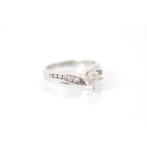 227A - A late 20th century diamond solitaire ring, the round cut diamond in white metal claw setting with s... 