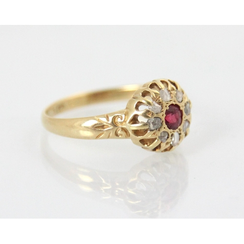 104 - An early 20th century 18ct diamond and untested ruby cluster ring, the round cut red stone within a ... 