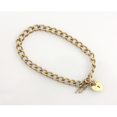 113 - A 9ct yellow gold bracelet, the curb link chain suspending a heart shaped padlock fastener, some lin... 