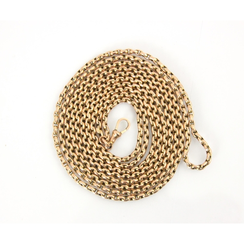 126 - An early 20th century yellow metal long guard chain, the slightly faceted oval links suspending lobs... 
