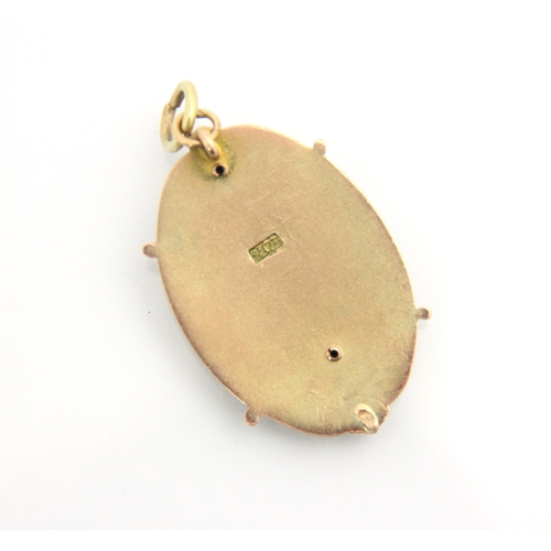 128 - A yellow metal pendant, the oval pendant with applied enamel shield motif surmounted by a knight, wi... 