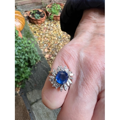 166 - A 1960's sapphire and diamond cluster ring, the central cushion cut sapphire within white metal claw... 