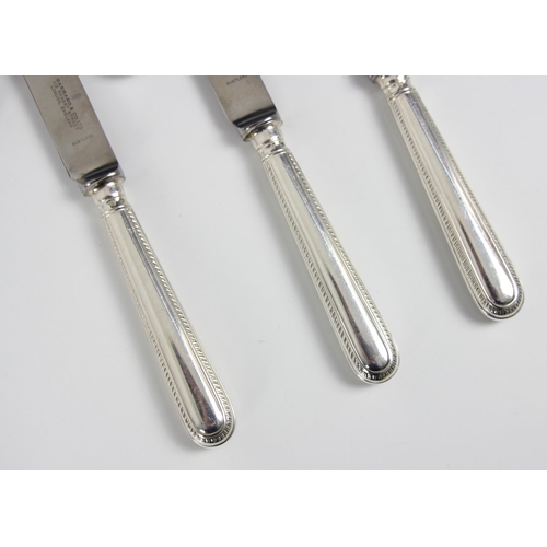 23 - A set of six silver handled feather edge pattern table knives, Garrard and Co, London 1961-62, the h... 