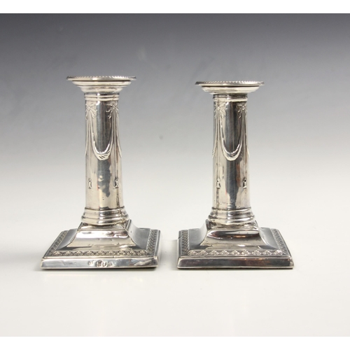 28 - A near pair of Edwardian silver candlesticks, possibly Thomas Bradbury & Sons, London 1903-1904, the... 