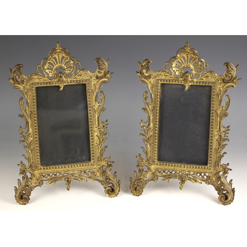 519 - A pair of Victorian gilt-metal Rococo revival photograph frames, each with easel back supports, each... 