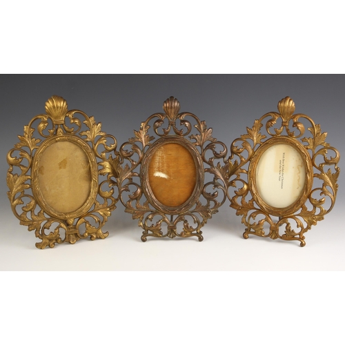 520 - A set of three Victorian gilt-metal Florentine type photograph frames, each of oval form and cast wi... 