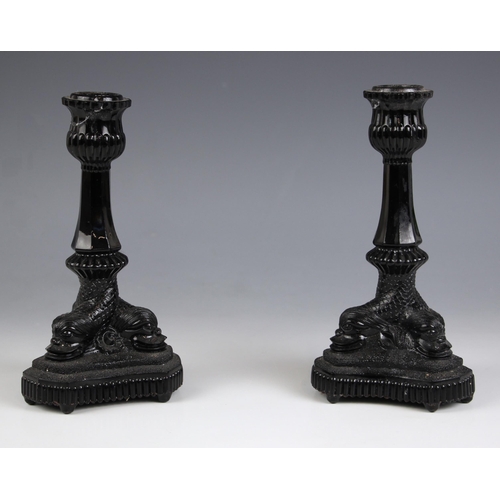 617 - A pair of Westmoreland black milk glass candlesticks, 20th century, the trefoil base modelled as thr... 