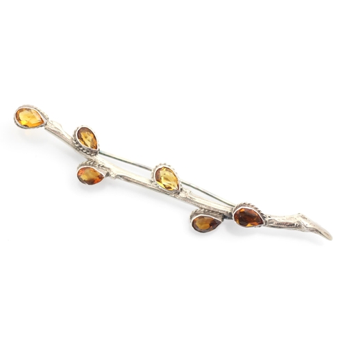 82 - A white metal and citrine brooch, the brooch designed as stylised sprig of pussy willow with six tea... 