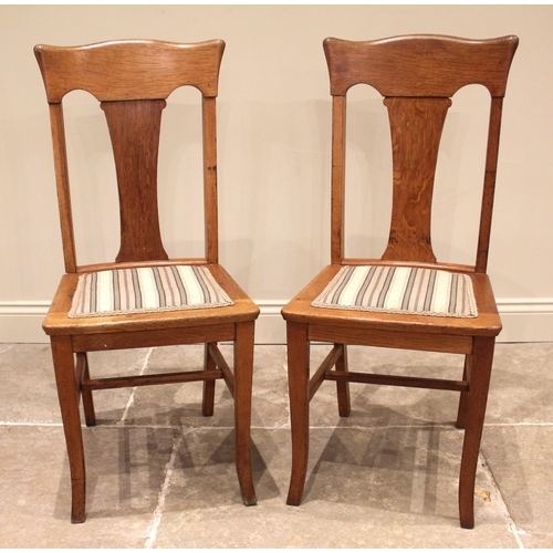 828 - A pair of Glasgow school style Arts & Crafts honey oak dining chairs, early 20th century, each chair... 