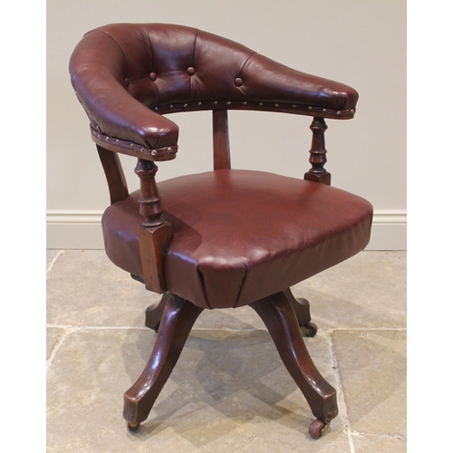 836 - A walnut revolving desk chair, early 20th century, later re-covered in ox-blood red leather, the arc... 