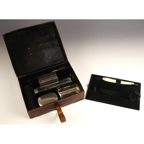 184 - A crocodile skin gentleman's travel vanity case, early 20th century, the cover mounted with an engra... 