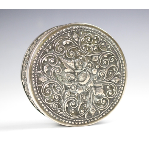 44 - A white metal box and cover, possibly Indian, the pull off circular cover with embossed scrolling an... 