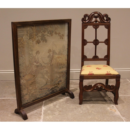 818 - A 19th century oak low seat side chair, with a carved scroll crest over a lunette and flowerhead rai... 