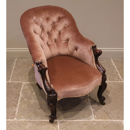 820 - A Victorian walnut and pink velour button back tub chair, the arched back extending to carved scroll... 