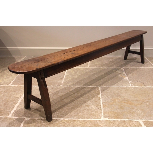 825 - A 19th century oak long bench or form, the rectangular top with rounded ends, upon trestle type supp... 