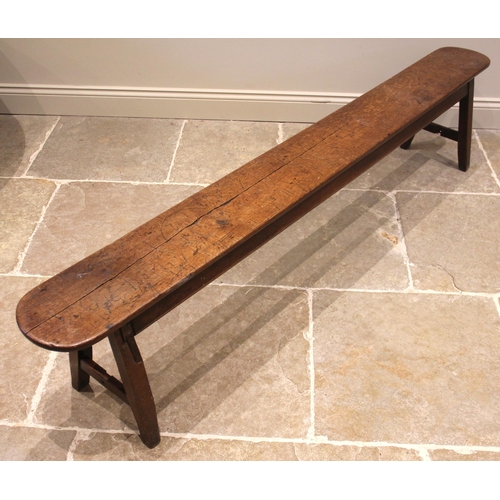 825 - A 19th century oak long bench or form, the rectangular top with rounded ends, upon trestle type supp... 