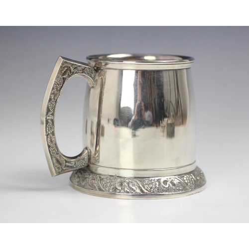 46 - A group of silver coloured items, to include a silver plated mug, the barrel shaped body upon spread... 