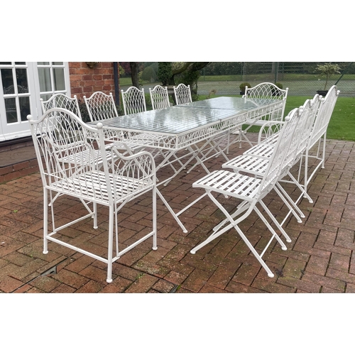 867 - A white painted wrought-iron alfresco dining set, comprising; a pair of strapwork and wire work glas... 