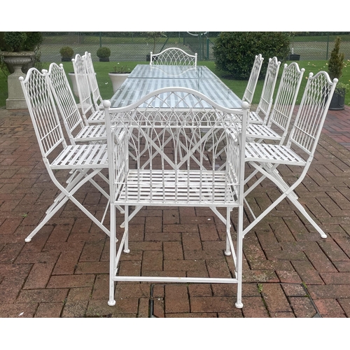 867 - A white painted wrought-iron alfresco dining set, comprising; a pair of strapwork and wire work glas... 