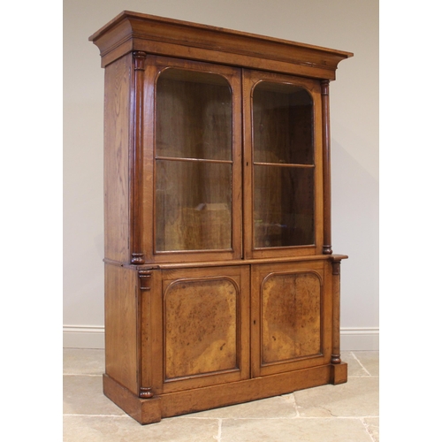 806 - A Victorian oak and pollard library bookcase, the cavetto cornice above a pair of glazed doors openi... 