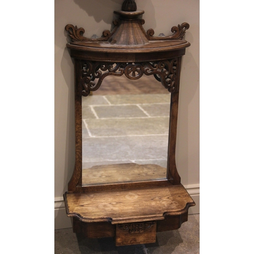 813 - A 19th century style carved oak mirror back wall shelf, the pagoda top above scroll carved openwork ... 