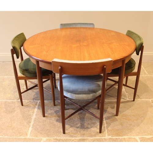 861 - A G-Plan Fresco teak dining suite, the circular top table with integral folding leaf, upon tapering ... 