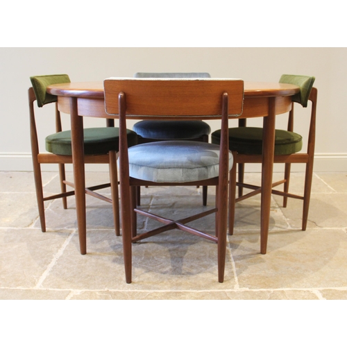 861 - A G-Plan Fresco teak dining suite, the circular top table with integral folding leaf, upon tapering ... 