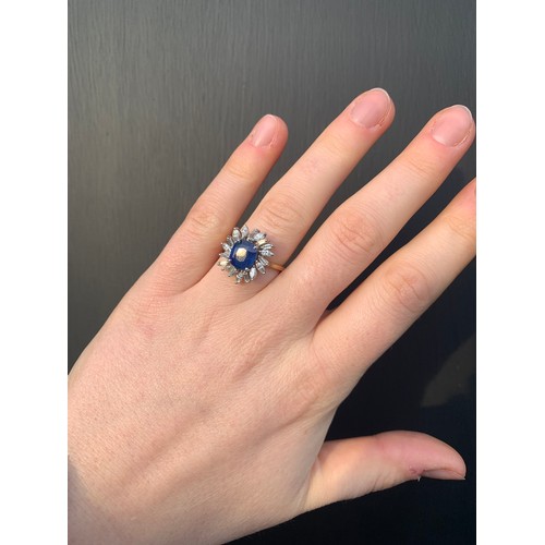 166 - A 1960's sapphire and diamond cluster ring, the central cushion cut sapphire within white metal claw... 