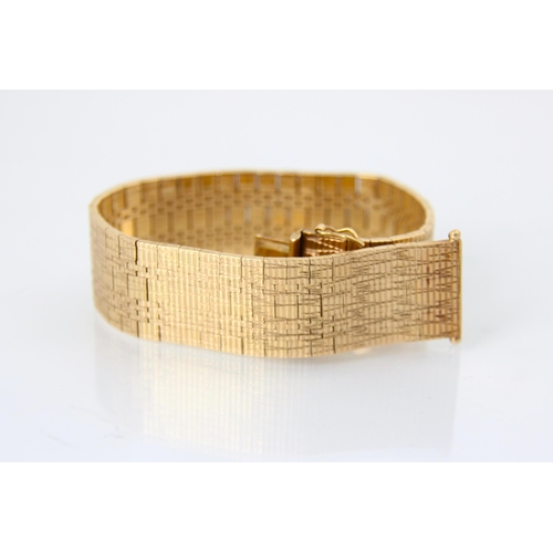 140 - A 9ct yellow gold bracelet, the flat snake link bracelet with continuous engraved detail, with box a... 