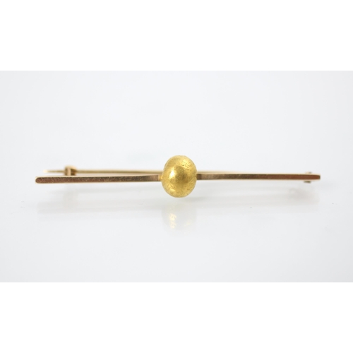 147 - A yellow metal bar brooch, the plain polished bar brooch with applied 'gold nugget', hinge pin to re... 