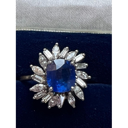 169 - A 1960's sapphire and diamond cluster ring, the central cushion cut sapphire within white metal claw... 