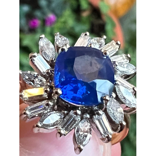 169 - A 1960's sapphire and diamond cluster ring, the central cushion cut sapphire within white metal claw... 