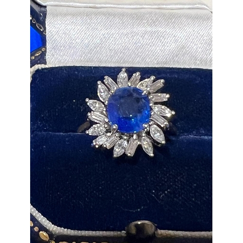 169 - A 1960's sapphire and diamond cluster ring, the central cushion cut sapphire within white metal claw... 