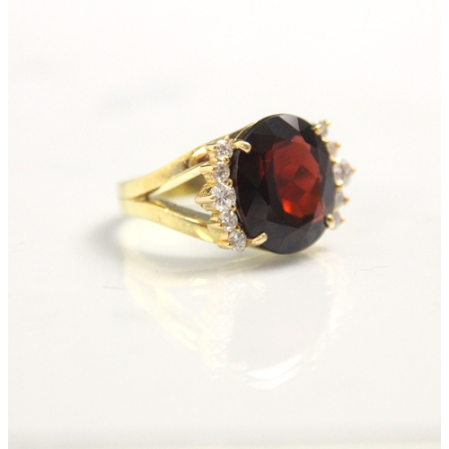 170 - A garnet and diamond dress ring, the oval cut garnet with five round cut diamonds to each side, with... 