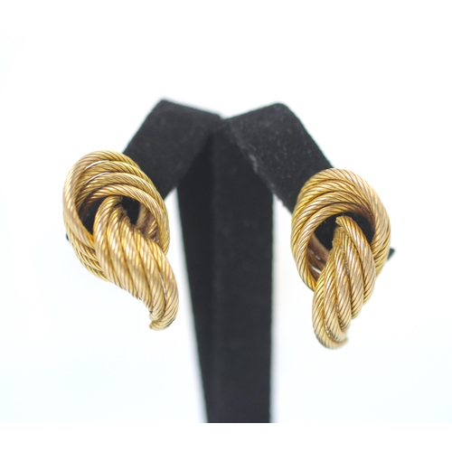 177 - A pair of yellow metal earrings, the stylised knot studs with engraved detail, with screw and butter... 